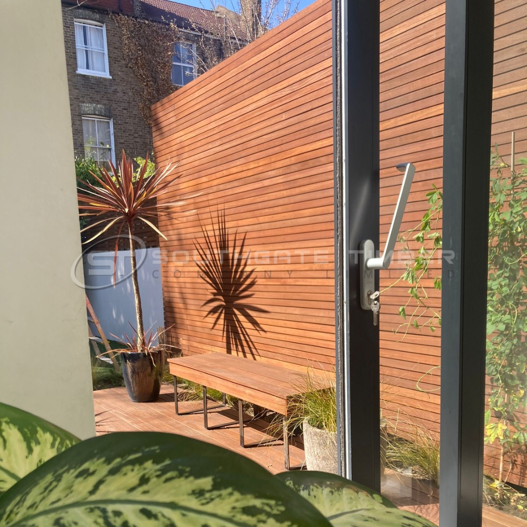 Yellow Balau hardwood fencing in a modern garden, showcasing golden-brown horizontal slats with a smooth finish, providing a durable and premium outdoor boundary, supplied by Southgate Timber.